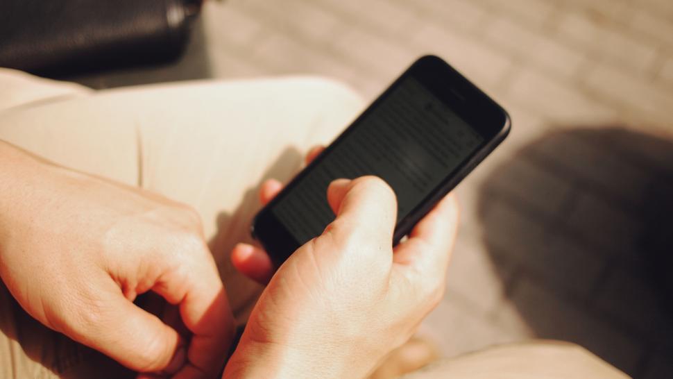 person-holding-smartphone-reading-text
